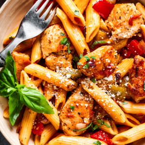 overhead close up of chicken and penne with tomatoes, peppers, and onions.