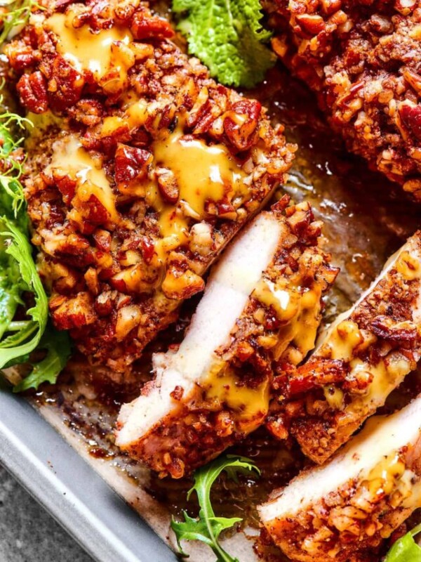 overhead photo of pecan crusted chicken, topped with honey mustard sauce, and sliced.
