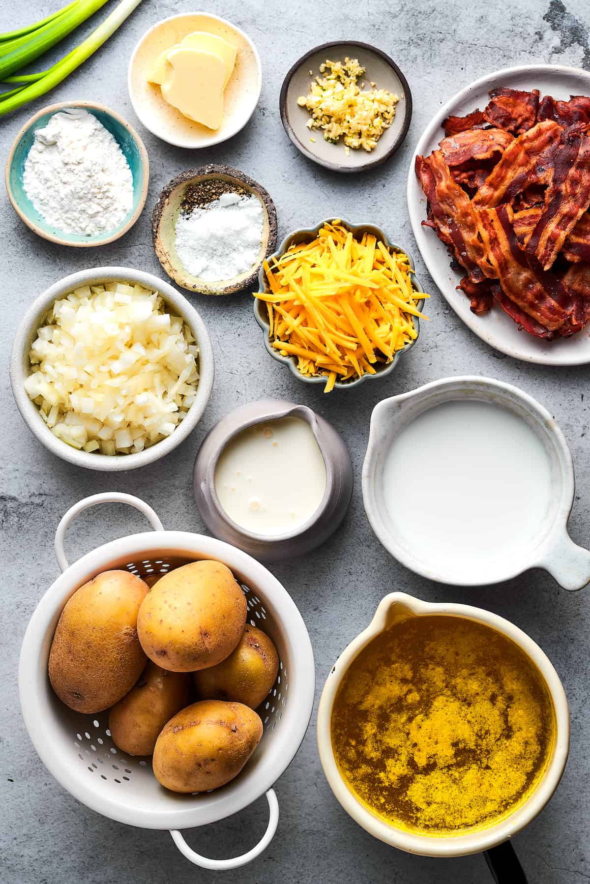 Ingredients for baked potato soup arranged on a work surface.