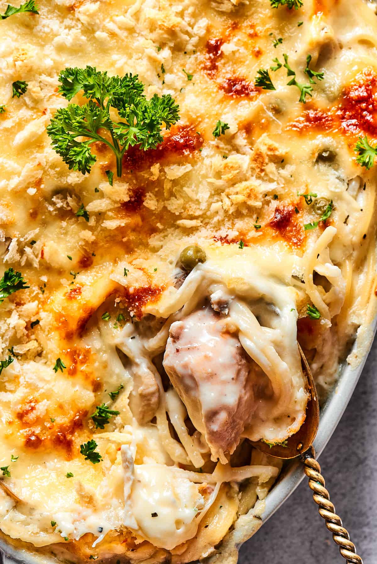 Spooning chicken tetrazzini out of a serving dish.