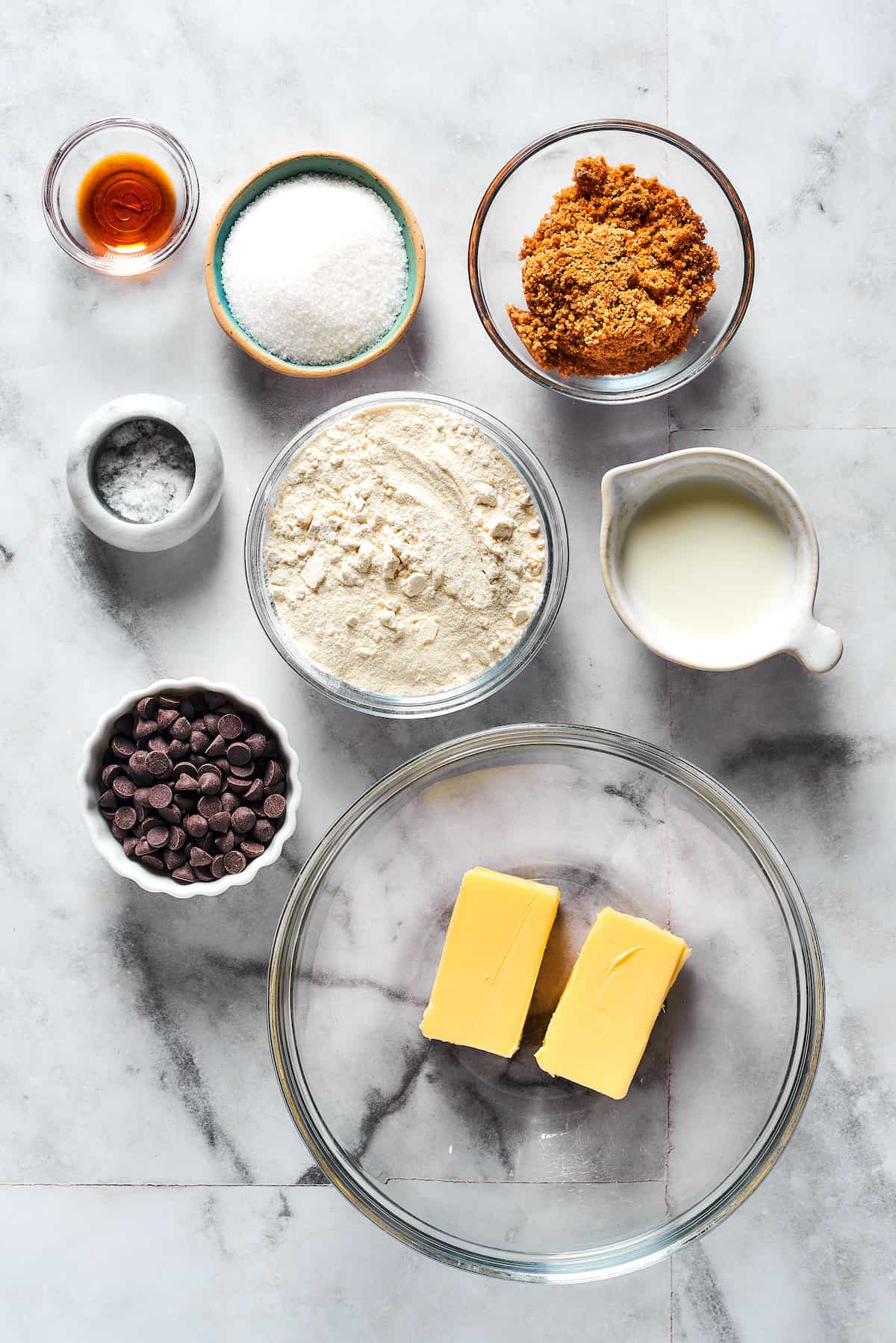 From top: Vanilla, granulated sugar, brown sugar, salt, flour, milk, chocolate chips, butter.