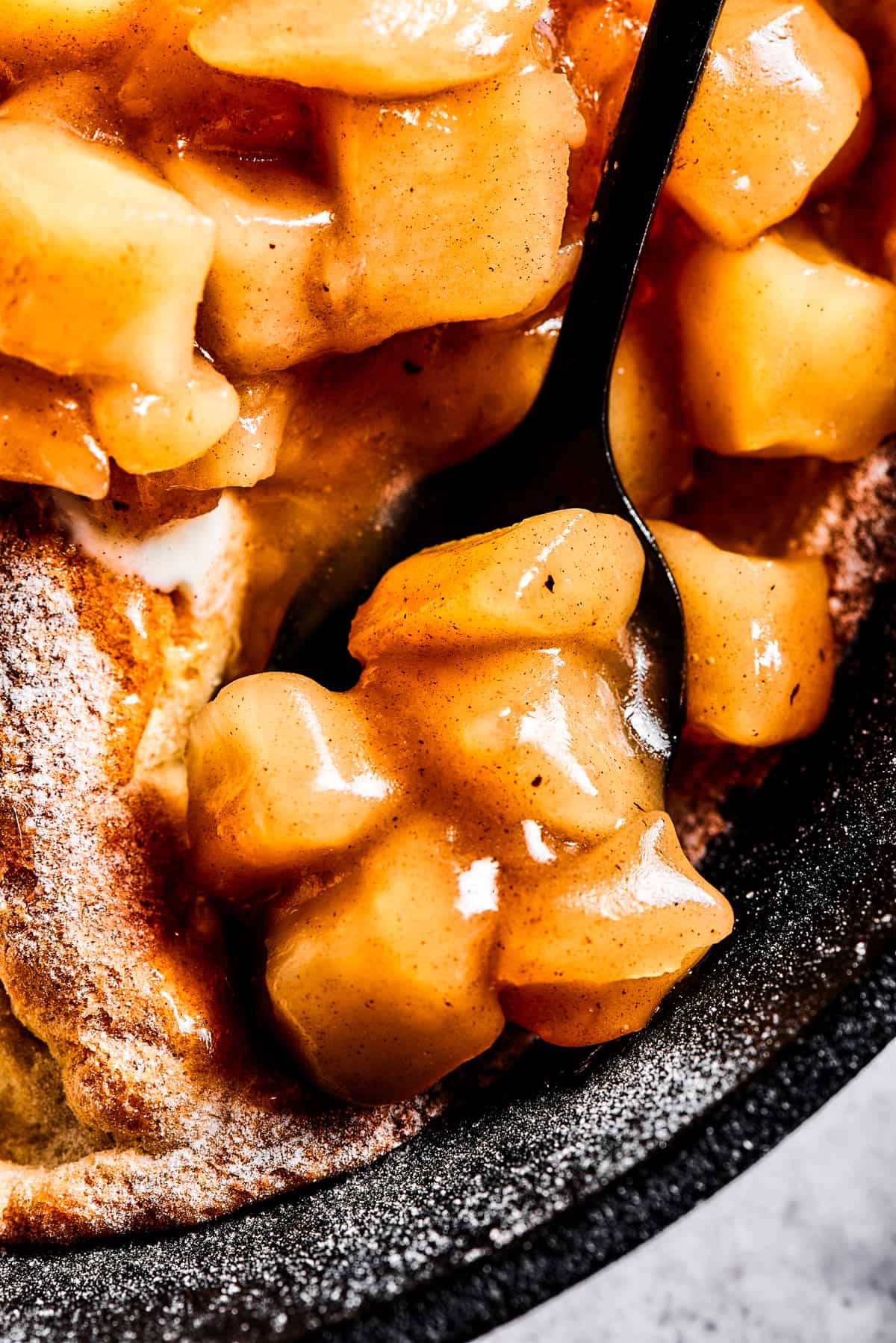 close up photo of a spoon with apple pie filling.