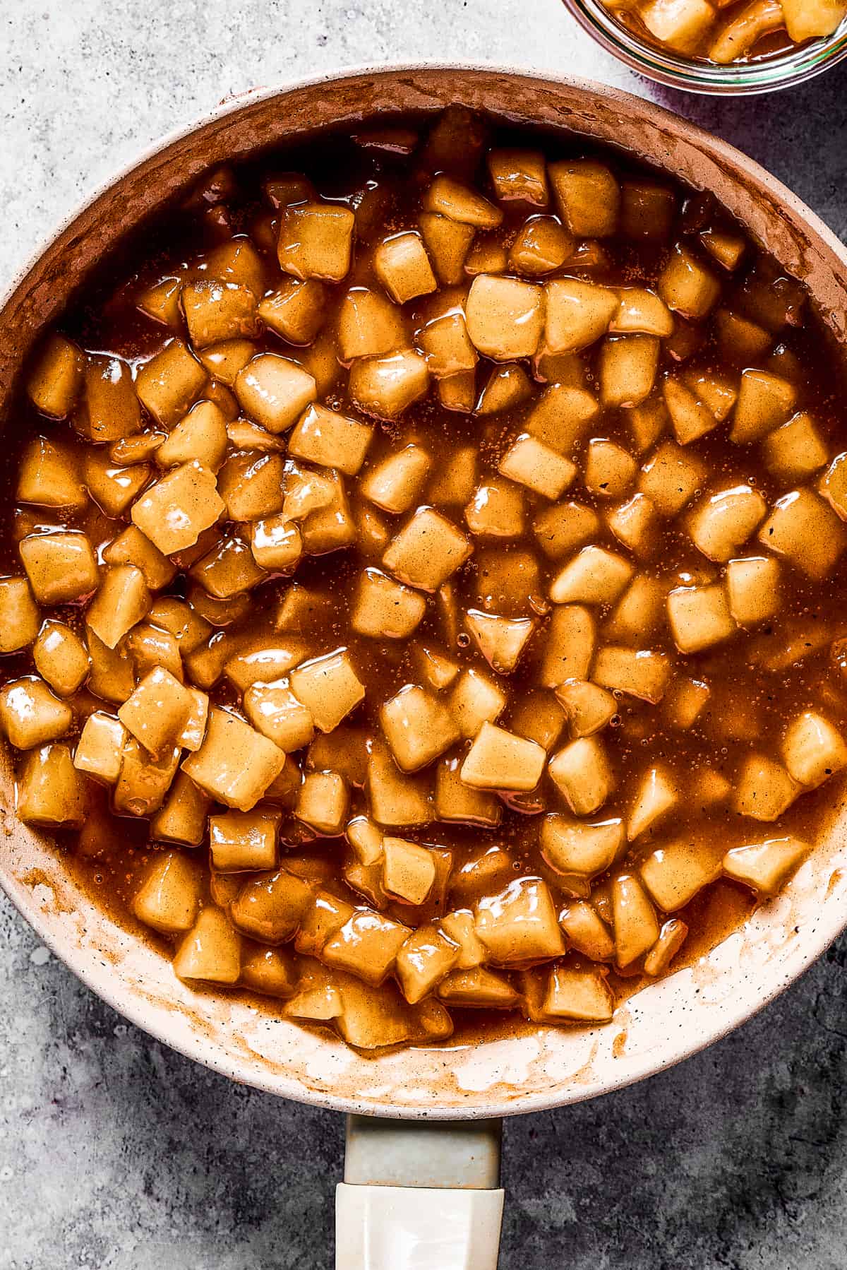 making homemade apple pie filling in a skillet.