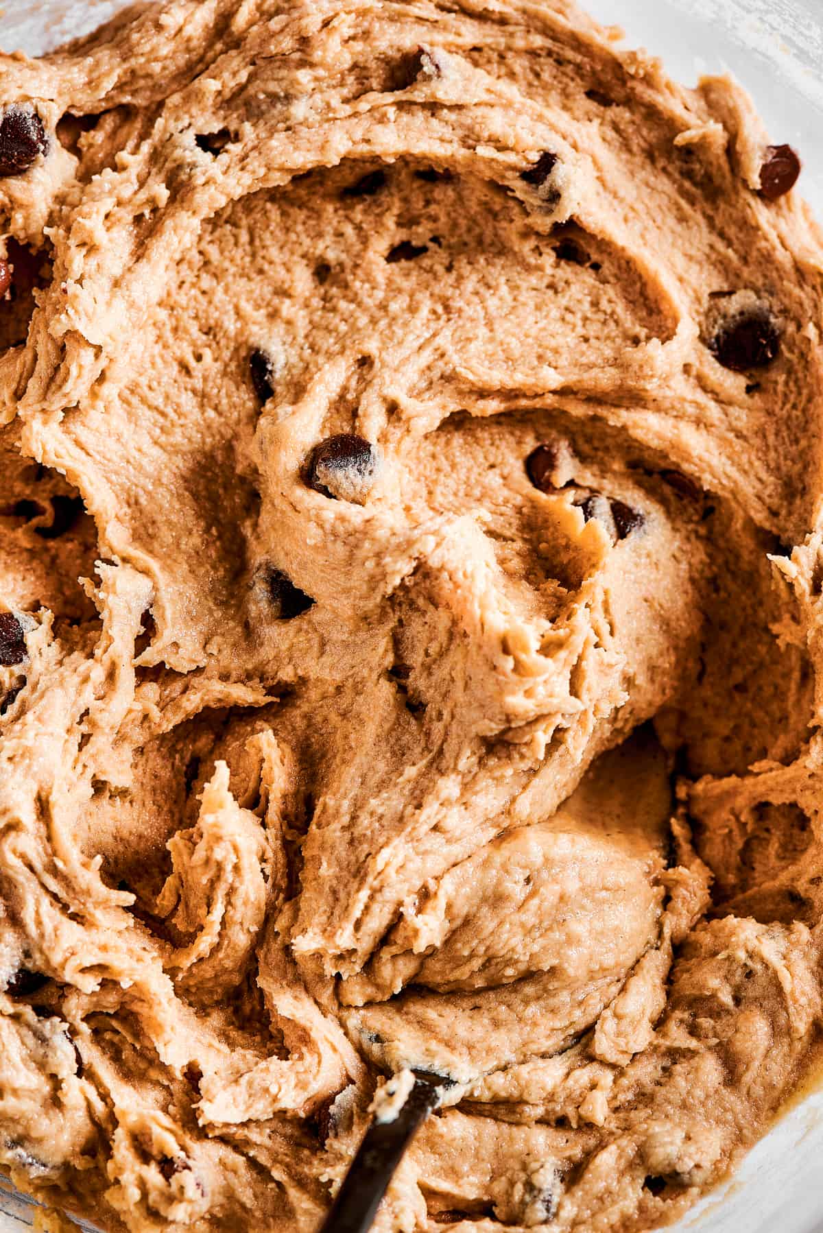 Close-up shot of a bowl full of chocolate chip cookie dough.