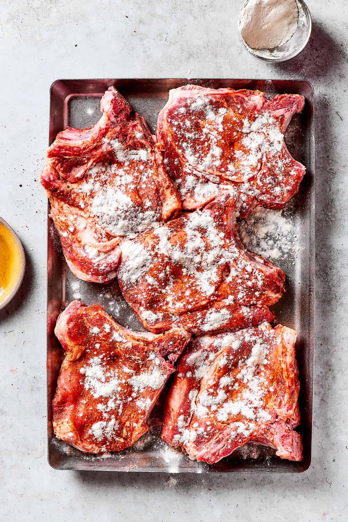 Dredged Pork Chops with Seasoned Flour Pork chops evenly coated with seasoned flour, ready for pan-frying.
