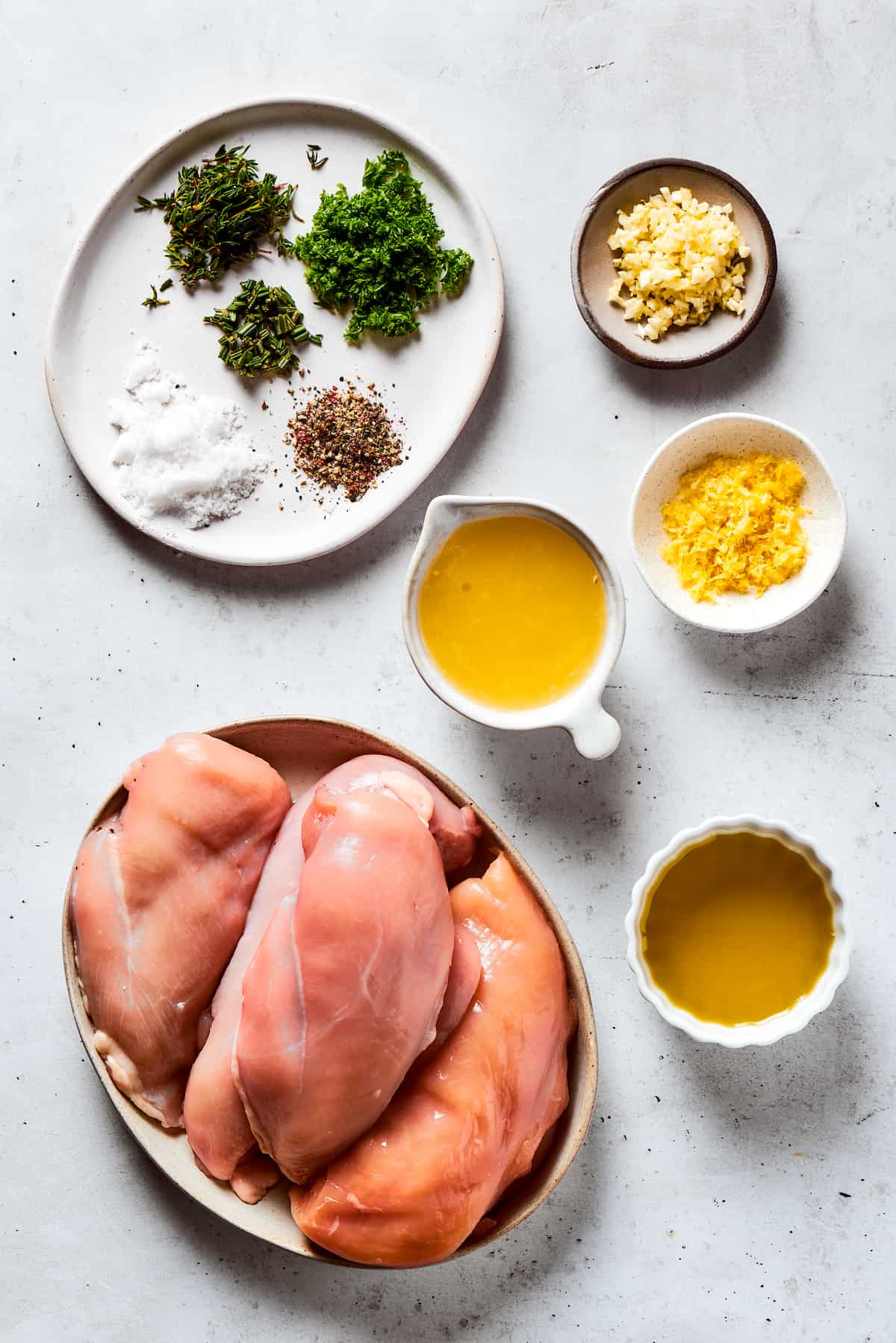 From top: Seasonings, garlic, lemon juice, chicken breasts, olive oil.