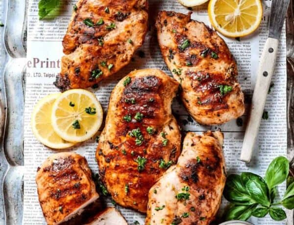 A large platter of grilled lemon chicken breasts.
