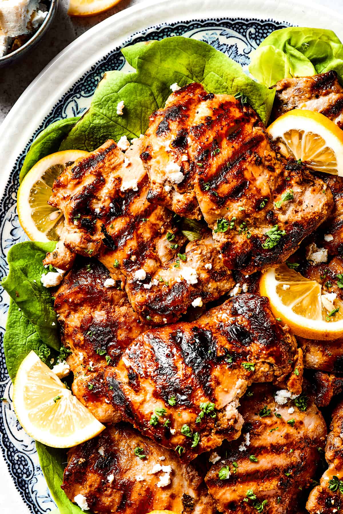 A platter of yogurt-marinated chicken with grill marks.