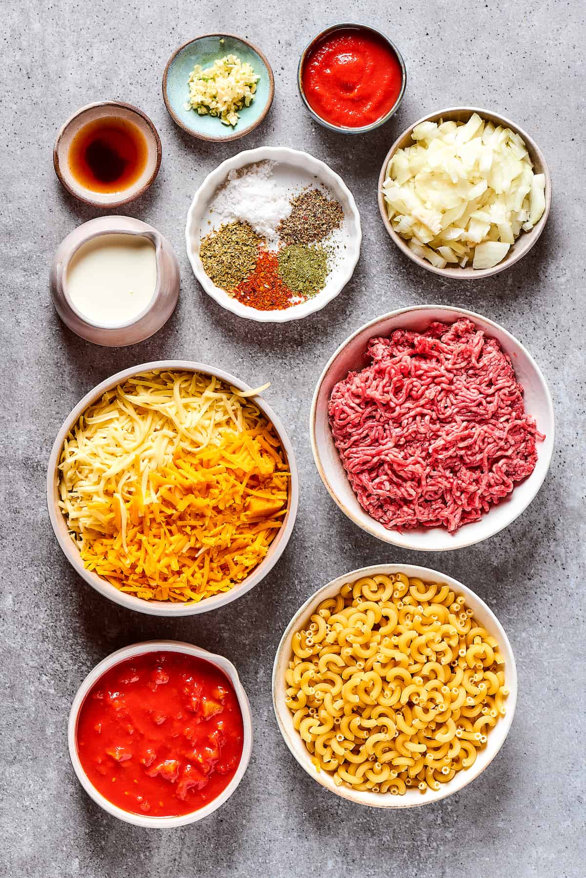Ingredients for cheeseburger casserole, measured and arranged on a work surface.