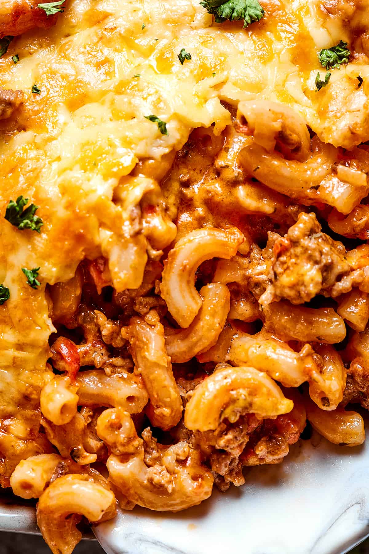 A close-up shot of a serving of macaroni casserole with beef and cheese.