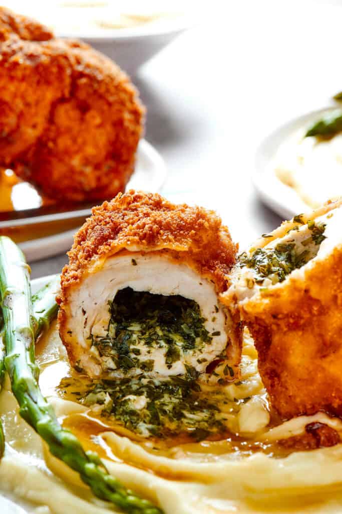 Chicken Kiev with garlic butter on a plate with side dishes.