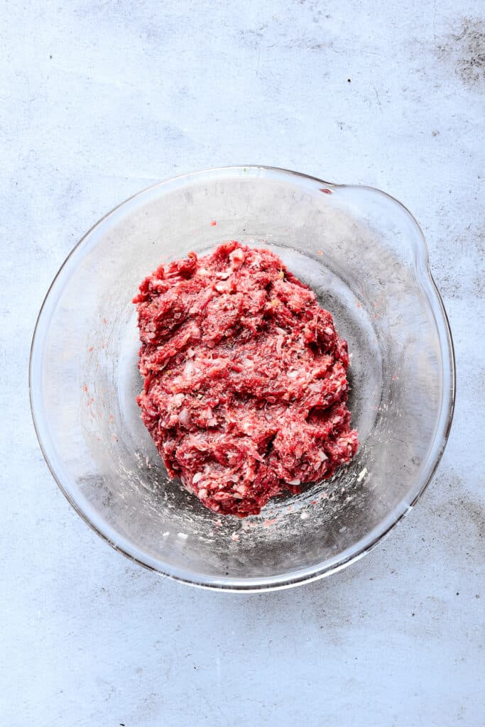 Ground beef patty mixture in a glass dish.