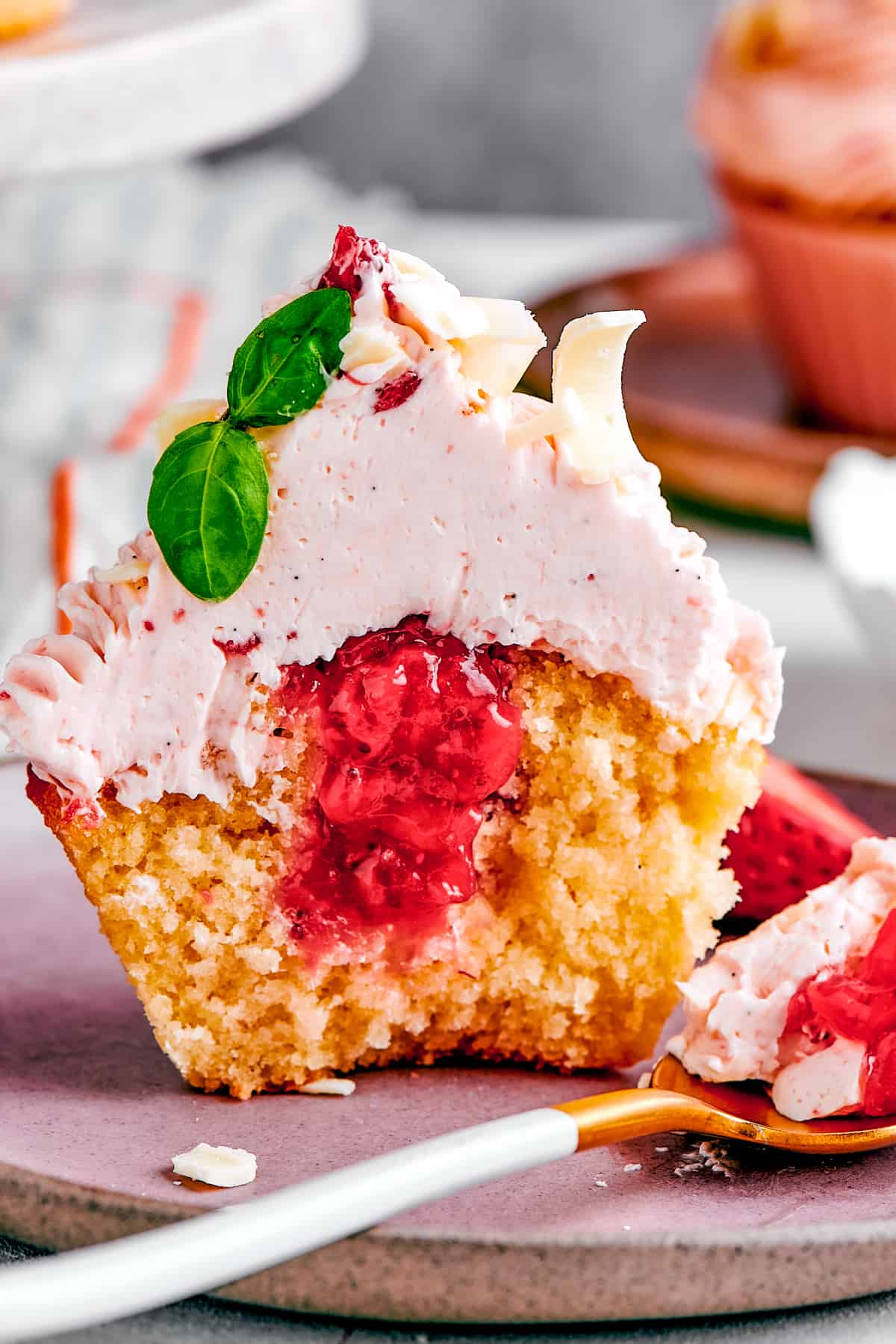 A strawberry cupcake, cut in half to show the filling.