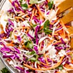 Stirring through shredded red and green cabbage and carrots.