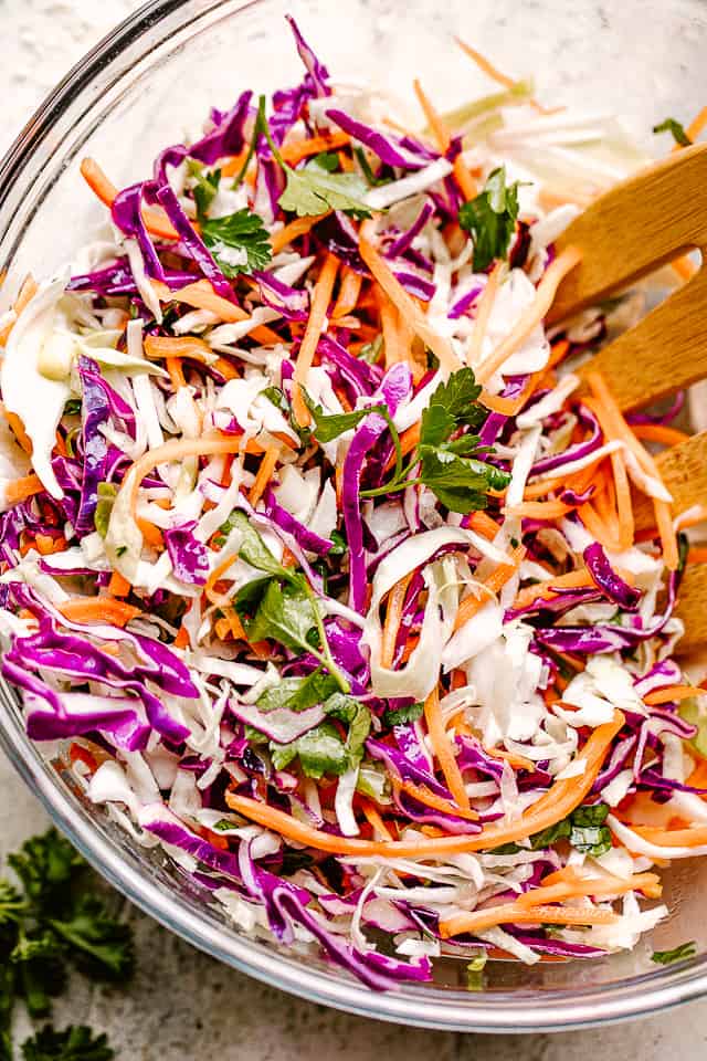 Stirring through shredded red and green cabbage and carrots.