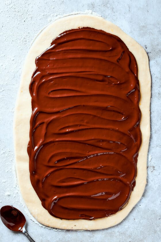 Chocolate spread out over a rectangle of dough.