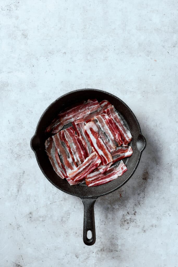 Frying bacon in a skillet.
