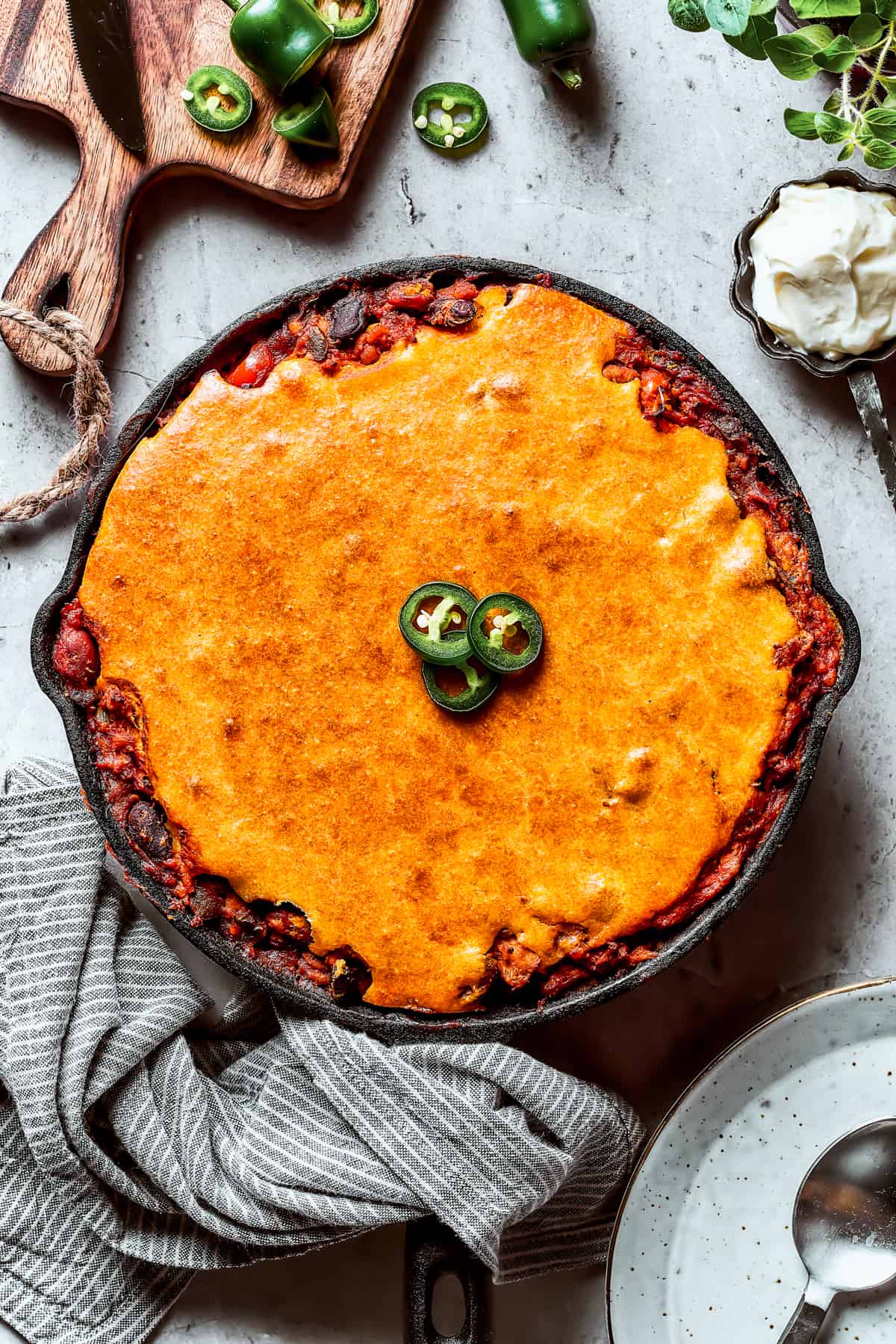 Chili with cornbread baked on top, garnished with jalapenos.