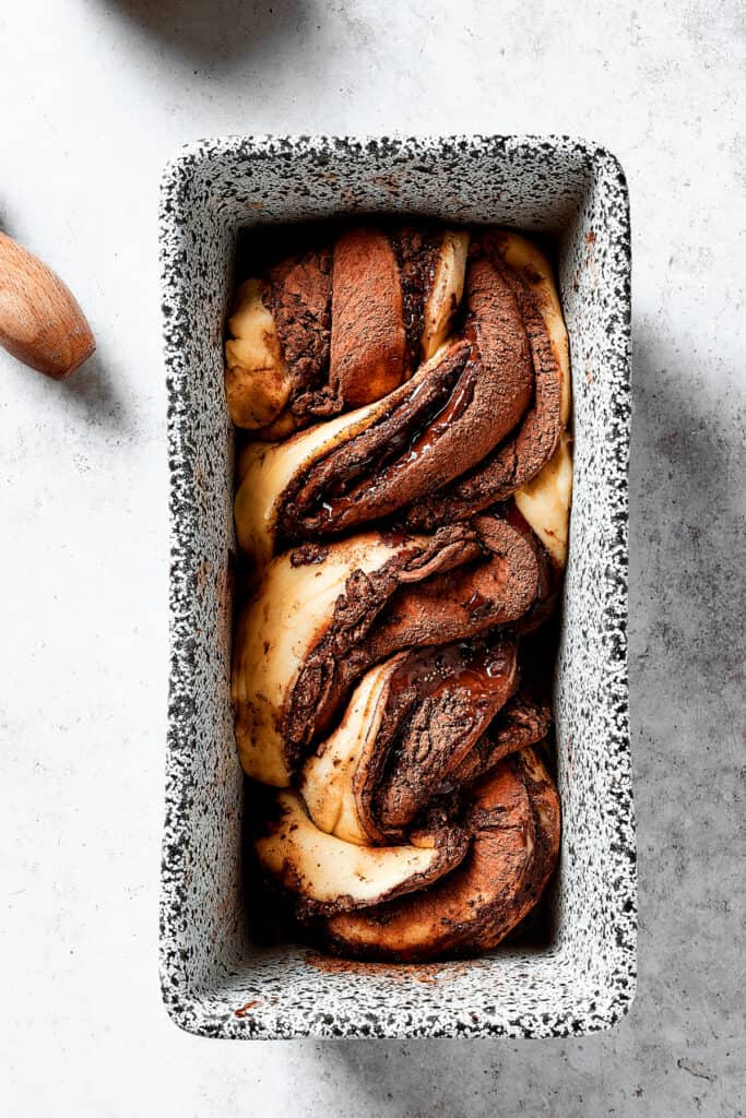 Twisted lengths of chocolate-filled dough placed in a loaf pan.
