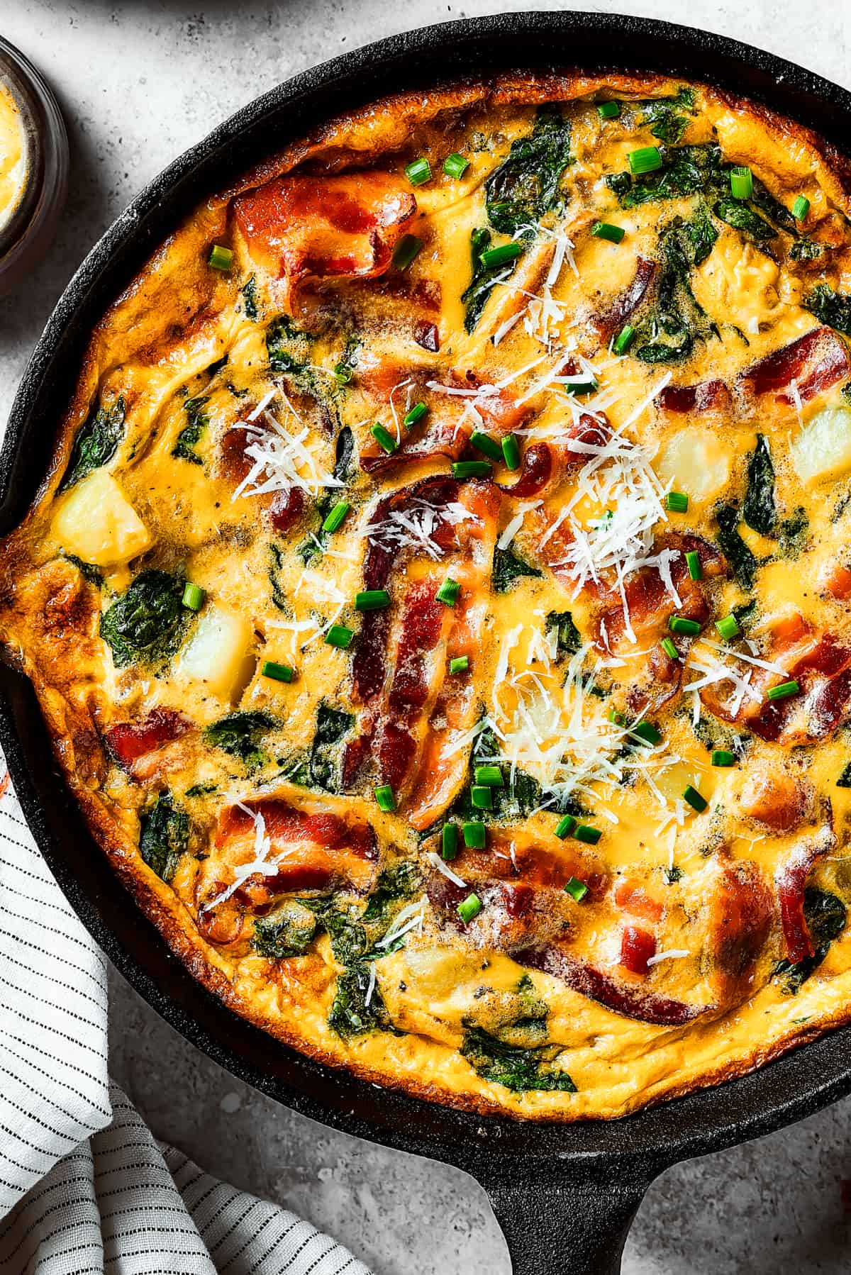 Close-up overhead shot of a fully-cooked frittata in a cast-iron pan.