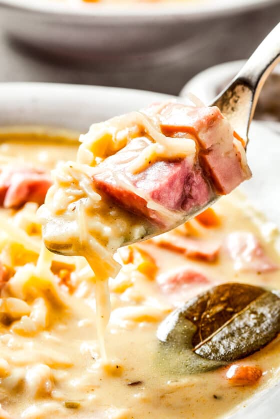 Lifting reuben soup out of a bowl with a spoon.