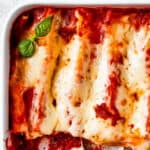 Close-up of baked manicotti that has been cut into and served.