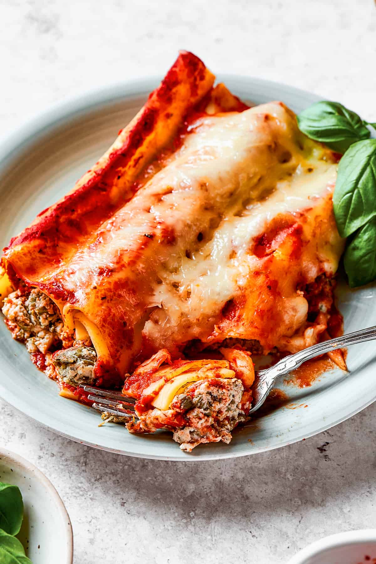 Piercing baked manicotti with a fork.