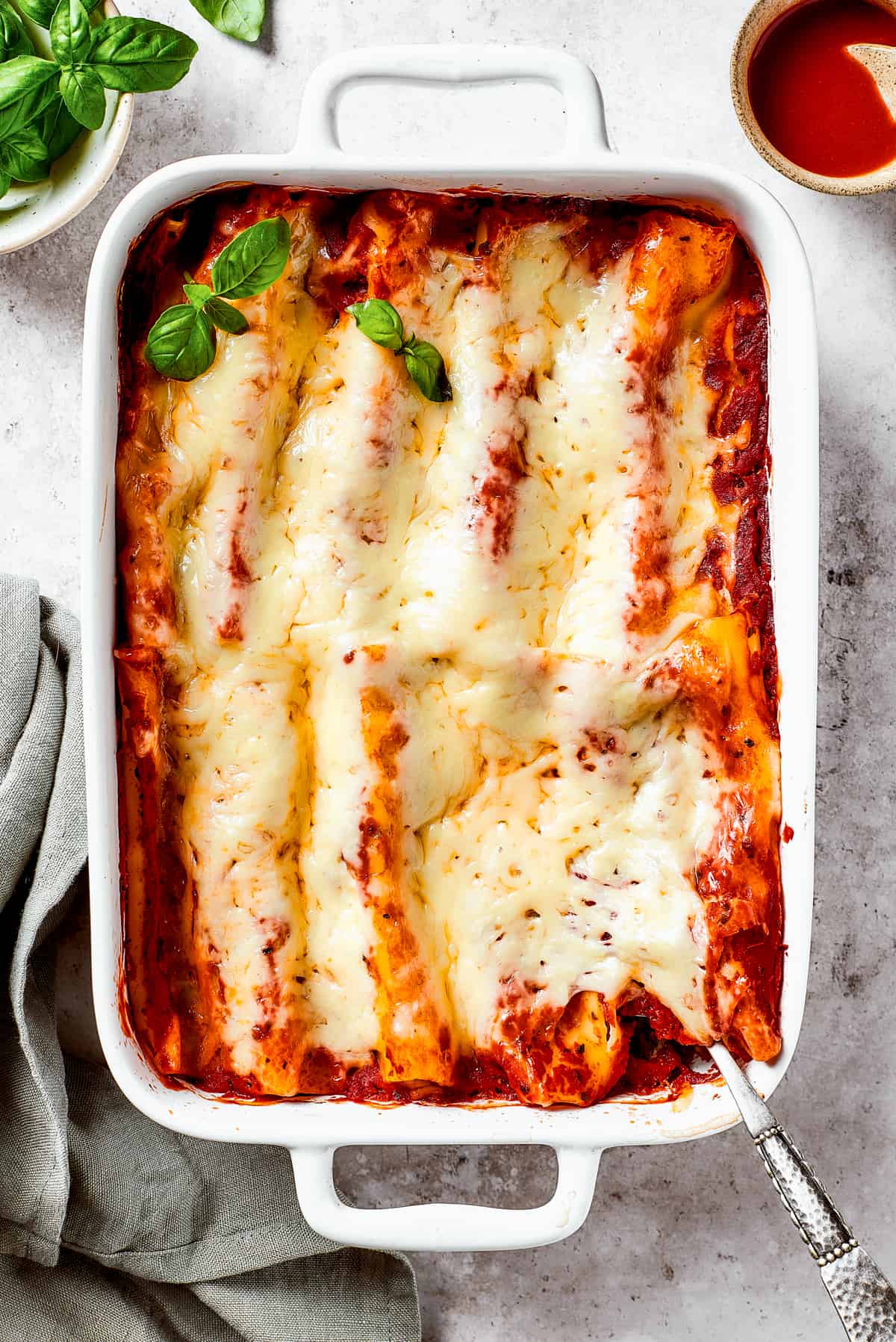 Baked pasta in a dish garnished with fresh basil.