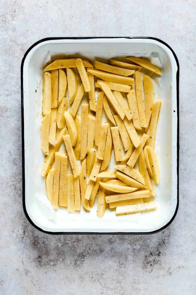 Unbaked fries in a baking dish.