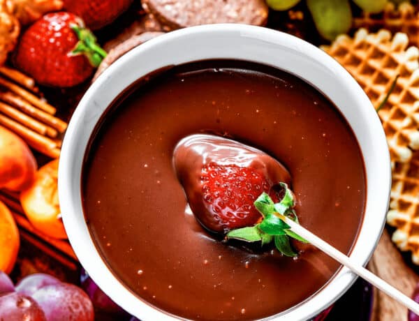 Dipping a strawberry in chocolate fondue.