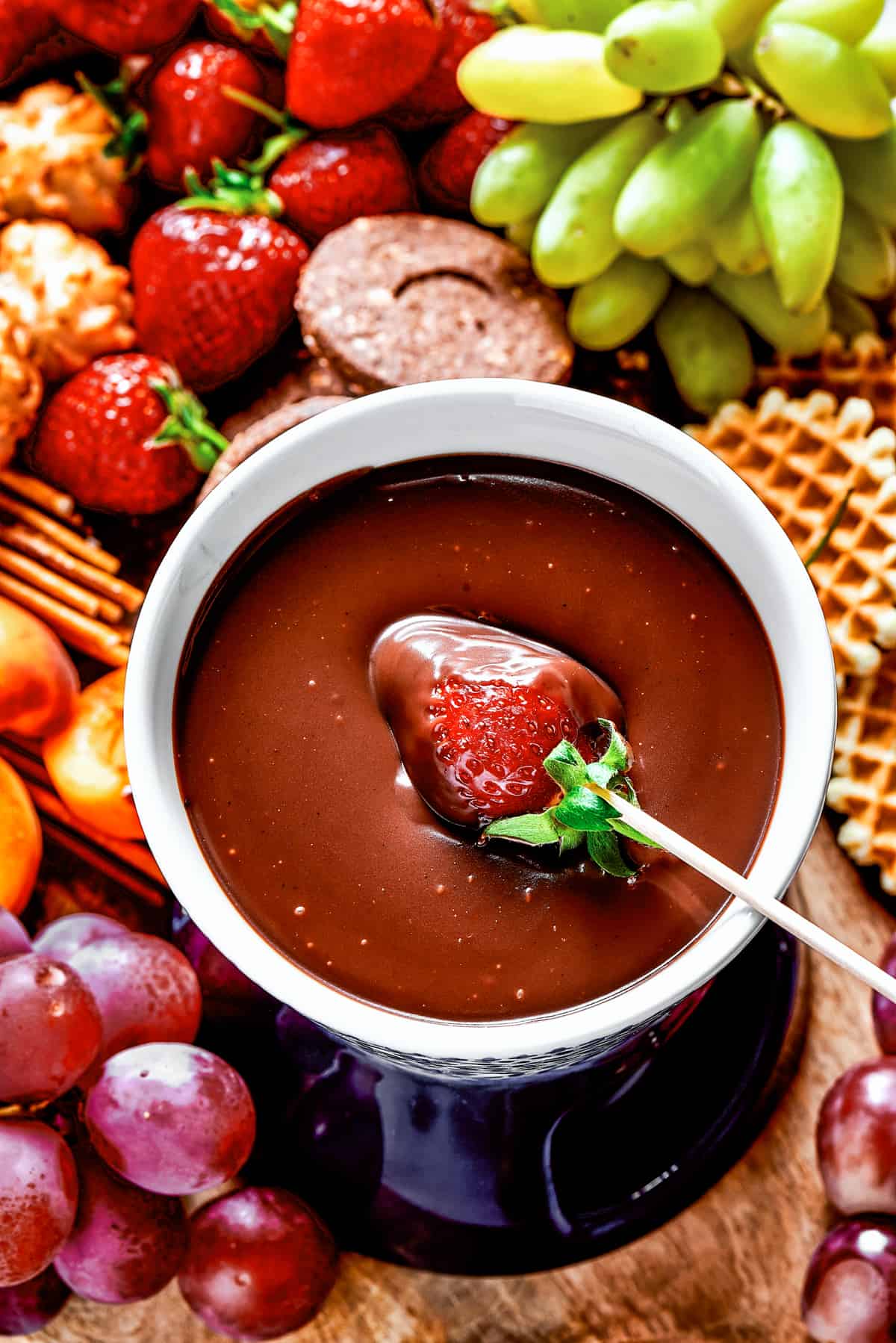 Dipping a strawberry in chocolate fondue.
