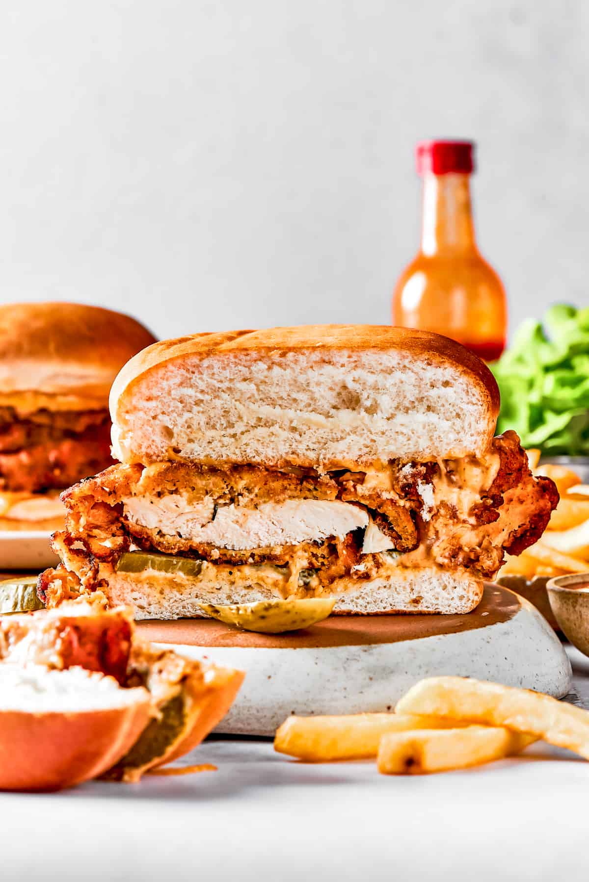 A homemade chicken sandwich cut in half to show the texture of the fried chicken and bun.