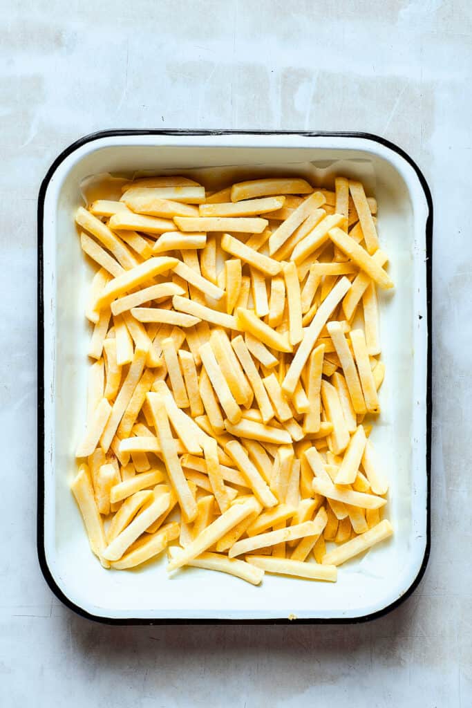 Frozen french fries on a baking sheet.