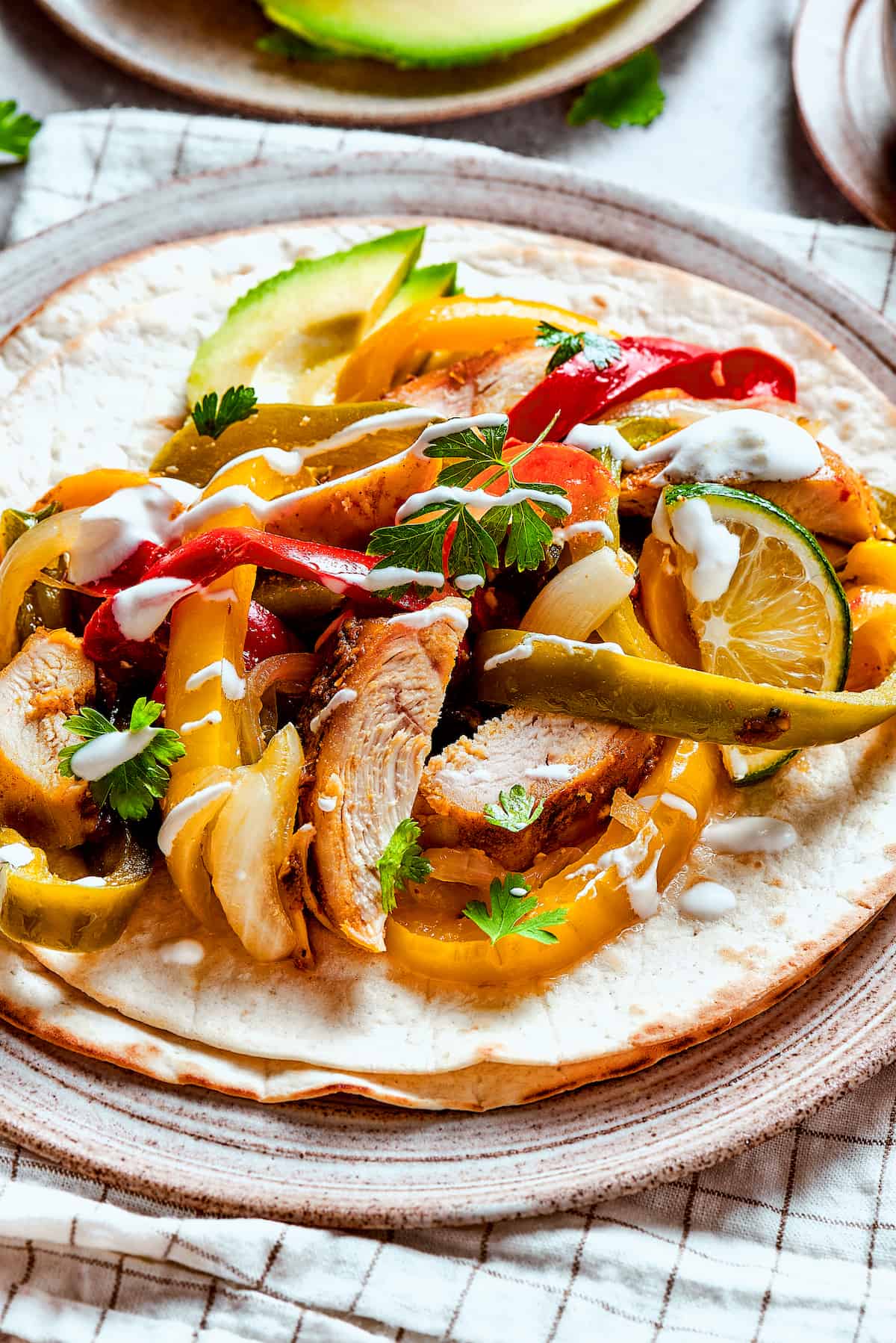 Homemade chicken fajitas with vegetables and lime slices.