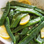 Garlic Butter Romano Beans served with lemon slices.