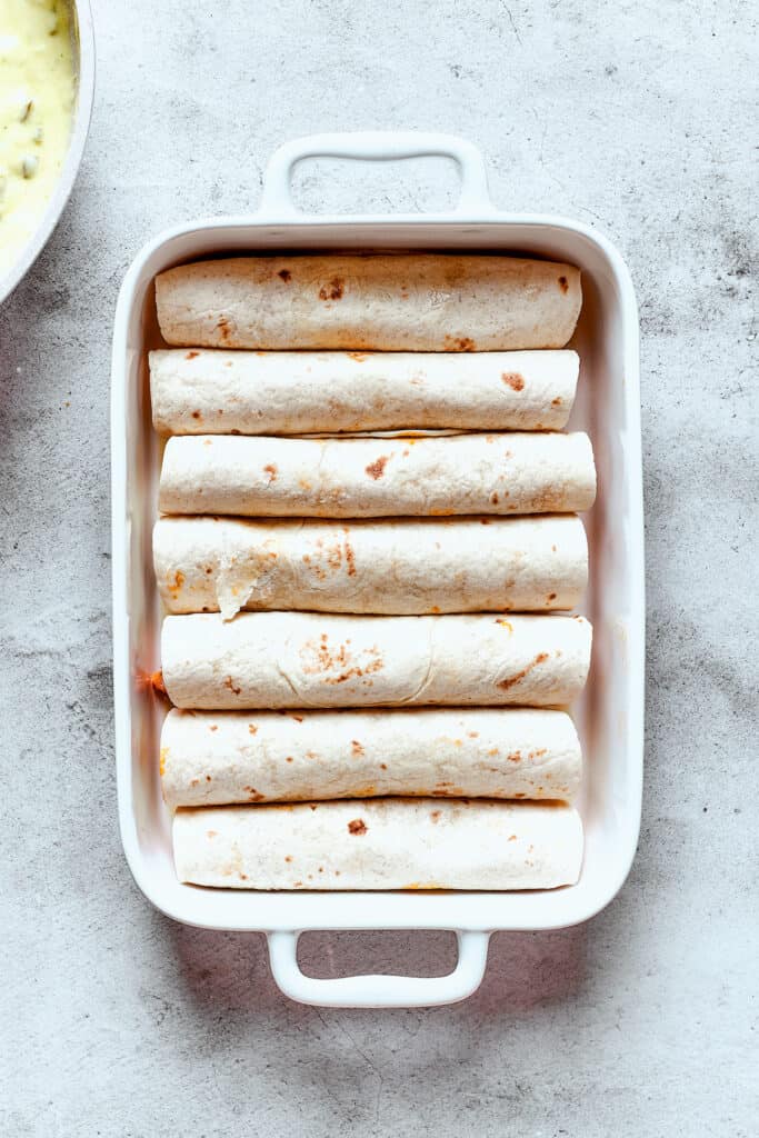 A baking dish full of rolled-up enchiladas.