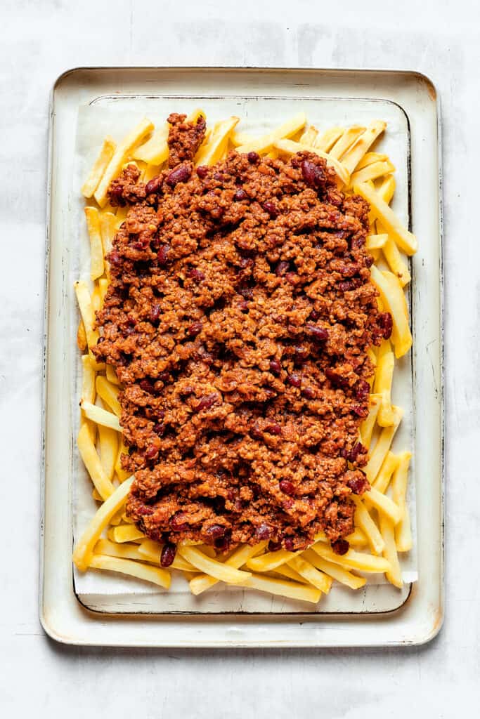 A baking sheet with french fries covered in chili.
