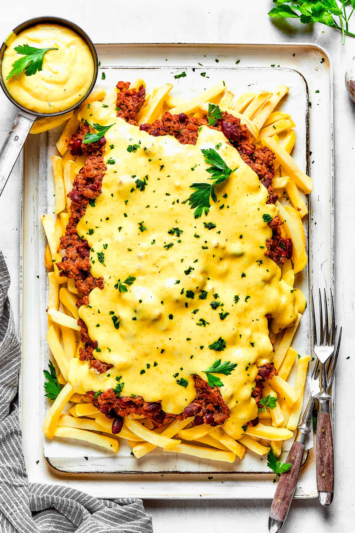 Cheese sauce poured over a batch of chili fries.