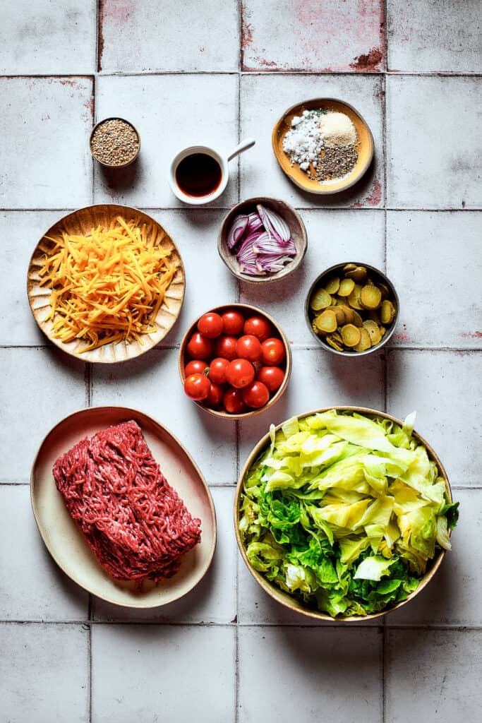 The ingredients for Big Mac salad, arranged on a work surface.