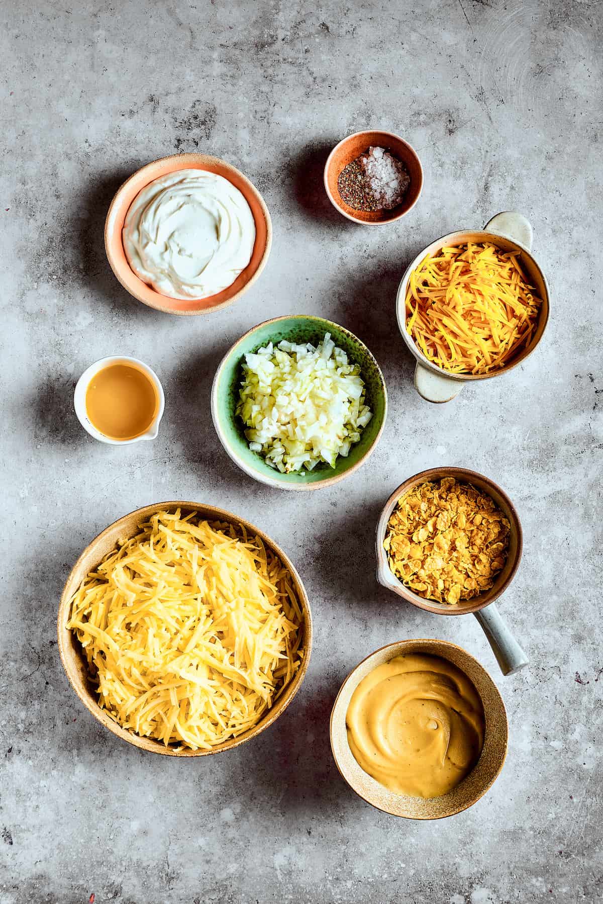 Ingredients for cheesy hashbrown casserole measured and arranged on a work surface.
