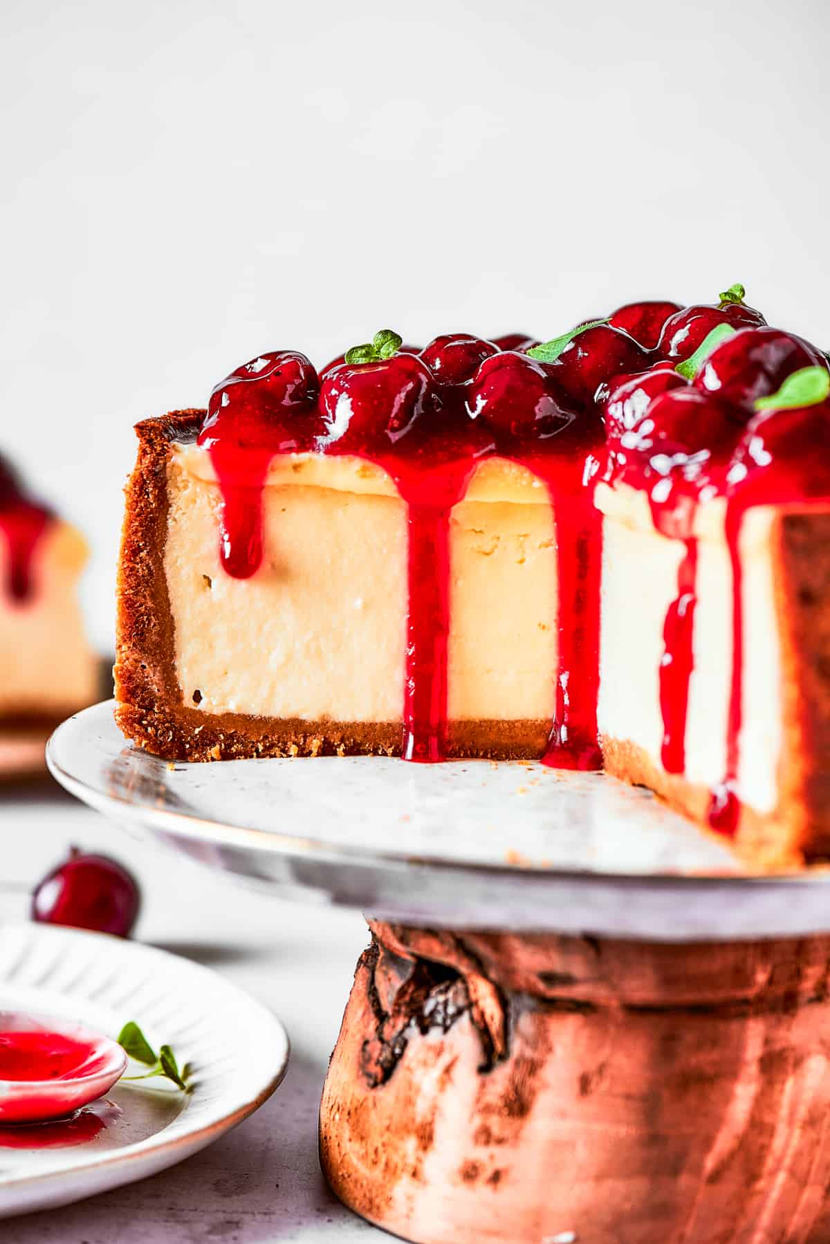 Cherry cheesecake on a cake stand.