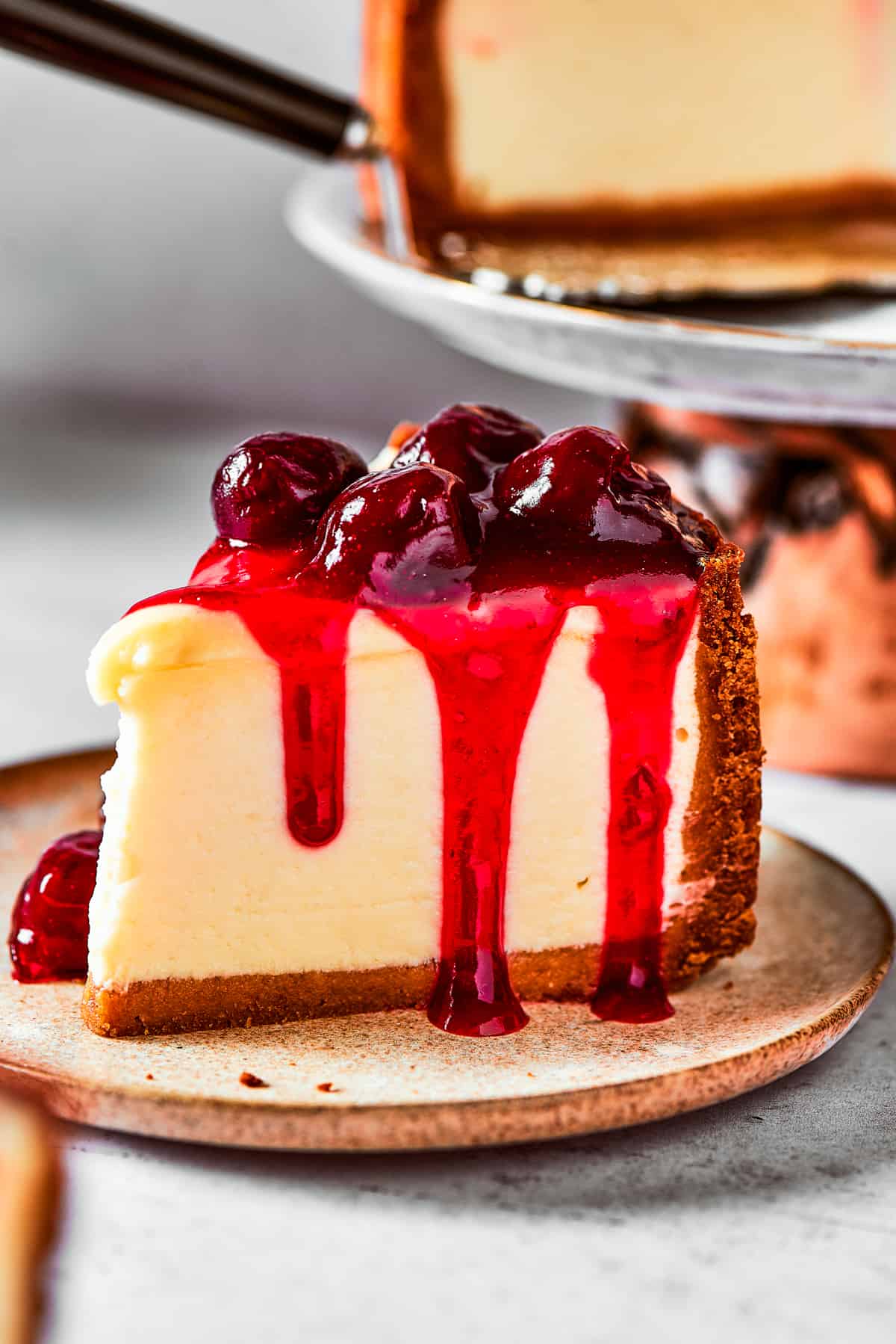 A slice of cherry cheesecake served on a small dessert plate.