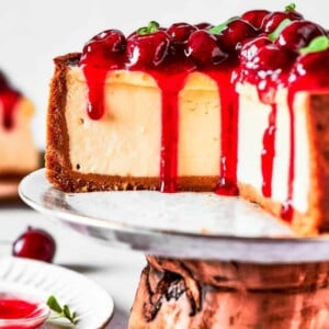 Cherry cheesecake on a cake stand.