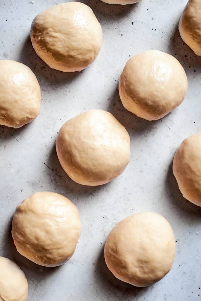 Balls of soft pretzel dough on a white background.