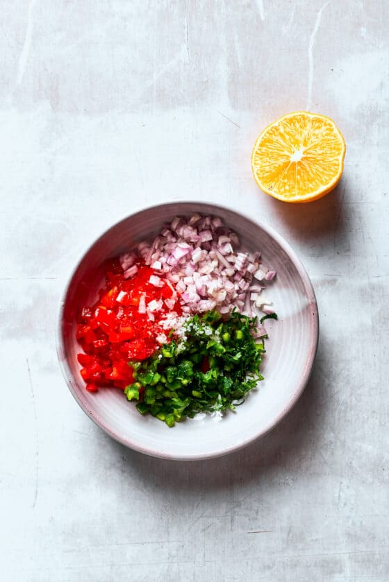 Pico de gallo ingredients are placed in a white bowl.