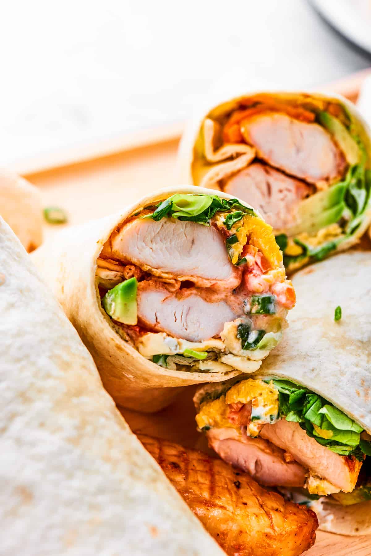 A halved buffalo chicken wrap shows the interior of chicken and vegetables.