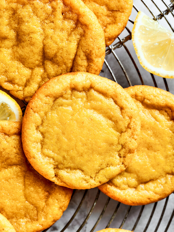 Close-up shot of several lemon cookies arranged on a round wire rack.