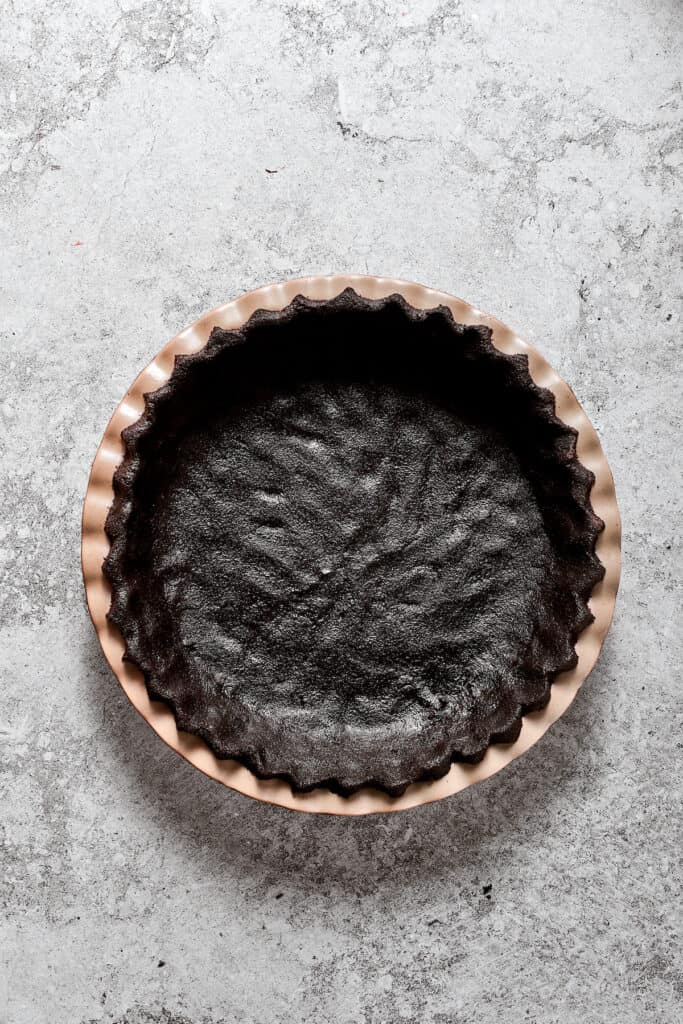 An Oreo cookie crust in a pie pan.