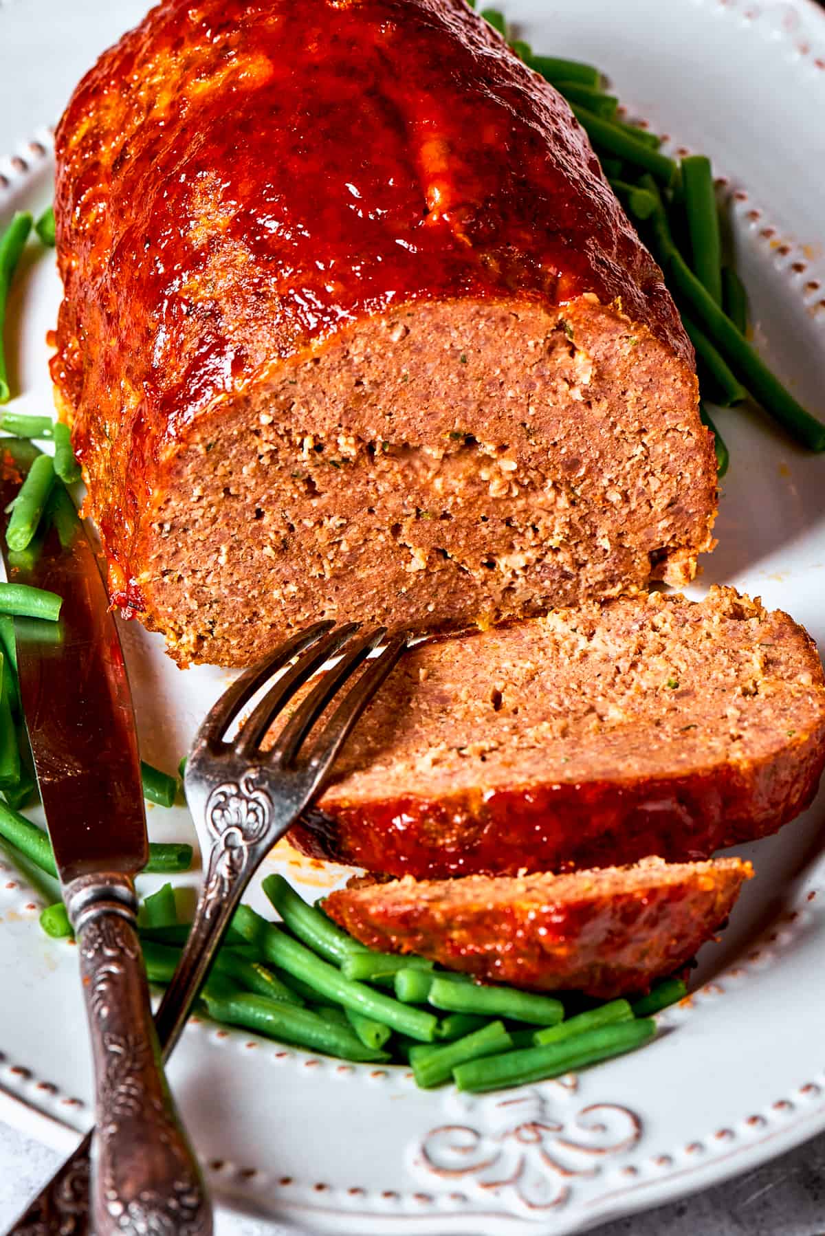 A side view of a sliced brown sugar meatloaf, exposing its texture.