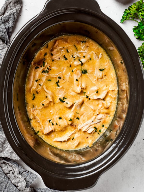 Chicken and gravy cooking in a slow cooker.